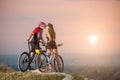 Couple bicyclist with mountain bikes on the hill at sunset Royalty Free Stock Photo