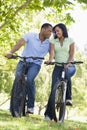 Couple on bikes outdoors smiling Royalty Free Stock Photo