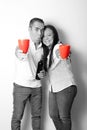 Latin adult couple in black and white show their love by toasting with red glasses for the arrival of February and celebrate Valen Royalty Free Stock Photo