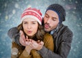 Couple blowing kisses against blue bokeh background Royalty Free Stock Photo