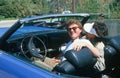 A couple in a blue Buick Electra convertible