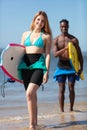 couple body boarders walking towards sea