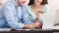 Couple booking tickets online on laptop with credit card