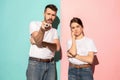 Couple bored watching tv with a the hand holding the remote control standing at studio Royalty Free Stock Photo