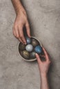 Couple with bowl of easter eggs on concrete surface Royalty Free Stock Photo