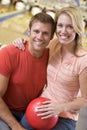 Couple in bowling alley holding ball and smiling Royalty Free Stock Photo