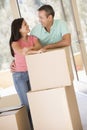 Couple with boxes in new home smiling Royalty Free Stock Photo