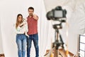 Couple of boyfriend and girlfriend with dog posing as model at photography studio pointing with finger to the camera and to you, Royalty Free Stock Photo