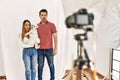 Couple of boyfriend and girlfriend with dog posing as model at photography studio scared and amazed with open mouth for surprise, Royalty Free Stock Photo