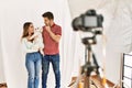 Couple of boyfriend and girlfriend with dog posing as model at photography studio serious face thinking about question with hand Royalty Free Stock Photo