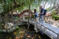 Couple feeding the Kois in Pond of Chinese Garden with entrance gate to Chikhan Temple, Tainan, Taiwan. Royalty Free Stock Photo