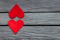 Couple of red paper hearts on gray wood, simple love story, break up