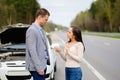 Couple and broken car on a highway Royalty Free Stock Photo