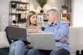 Couple browsing webstore via laptops while sitting on couch Royalty Free Stock Photo