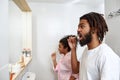 Couple brush teeth with toothbrushes in bathroom