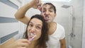 Couple brushing teeth in bathroom