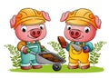 The couple builder pig are holding the bricks and wheelbarrow in the garden Royalty Free Stock Photo