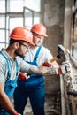 A couple of builders working together to remove plaster from a brick wall Royalty Free Stock Photo