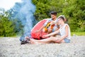 Couple burning sausages at campfire Royalty Free Stock Photo