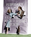 Couple bursting through leap year calendar Royalty Free Stock Photo