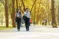 Businessman and businesswoman walking together within the park relaxed after work. Two businessmen holding cup of coffee Royalty Free Stock Photo