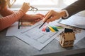 Couple buy or rent apartment together. Cut view of man and woman hands. She hold colorful pieces of tissues. He point on Royalty Free Stock Photo