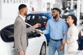 Couple Buying Car Taking Key From Salesman In Auto Showroom Royalty Free Stock Photo