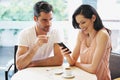 Couple, cafe and woman with cellphone texting or annoyed partner for internet distraction, social media or ignore. Man Royalty Free Stock Photo