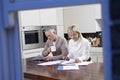 Couple Calculating Domestic Bills At Kitchen Table Royalty Free Stock Photo