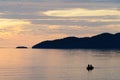 Couple canoeing by the shore in the sunset Royalty Free Stock Photo