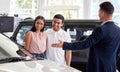 Couple at car dealership, choice and transportation with salesman, customer buying new transport with luxury. Sales Royalty Free Stock Photo