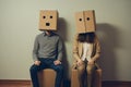 Couple with Cardboard Boxes on Heads Sitting Royalty Free Stock Photo