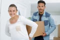 couple carrying box together in appartment Royalty Free Stock Photo