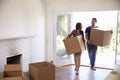 Couple Carrying Boxes Into New Home On Moving Day