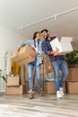 Couple carrying cardboard boxes with their stuff while moving in new apartment Royalty Free Stock Photo