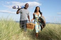 Couple Carrying Picnic Basket Walking Throug