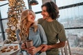 Couple casual stylish lovers are drinking coffee in the kitchen in new year morning. Young woman and her husband with a cups in Royalty Free Stock Photo