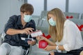 Couple Caucasian lovers man and woman with mask sit on chair with social distance and discuss about boarding pass in airport Royalty Free Stock Photo