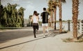 Couple of Caucasian men and Latina women run. Photographic shot from the back