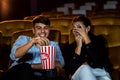 A couple of caucasian watch a movie in the cinema