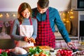 Couple celebrating Christmas in the kitchen cooking christmas duck or Goose