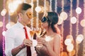 Couple celebrating New Year and drinking champagne on masquerade party