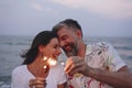 Couple celebrating with sparklers at the beach