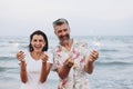 Couple celebrating with sparklers at the beach