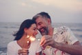 Couple celebrating with sparklers at the beach