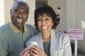 Couple With Cell Phone In Front Of New House