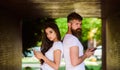 Couple chatting smartphones. Girl attractive brunette bearded hipster man stand back to back porch underground crossing Royalty Free Stock Photo