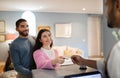 Couple Checking At Hotel Giving Credit Card To Receptionist Indoors Royalty Free Stock Photo