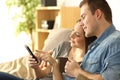 Couple checking a smart phone on a couch