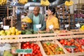 Couple choosing bananas in fruit and vegetable section of supermarket Royalty Free Stock Photo